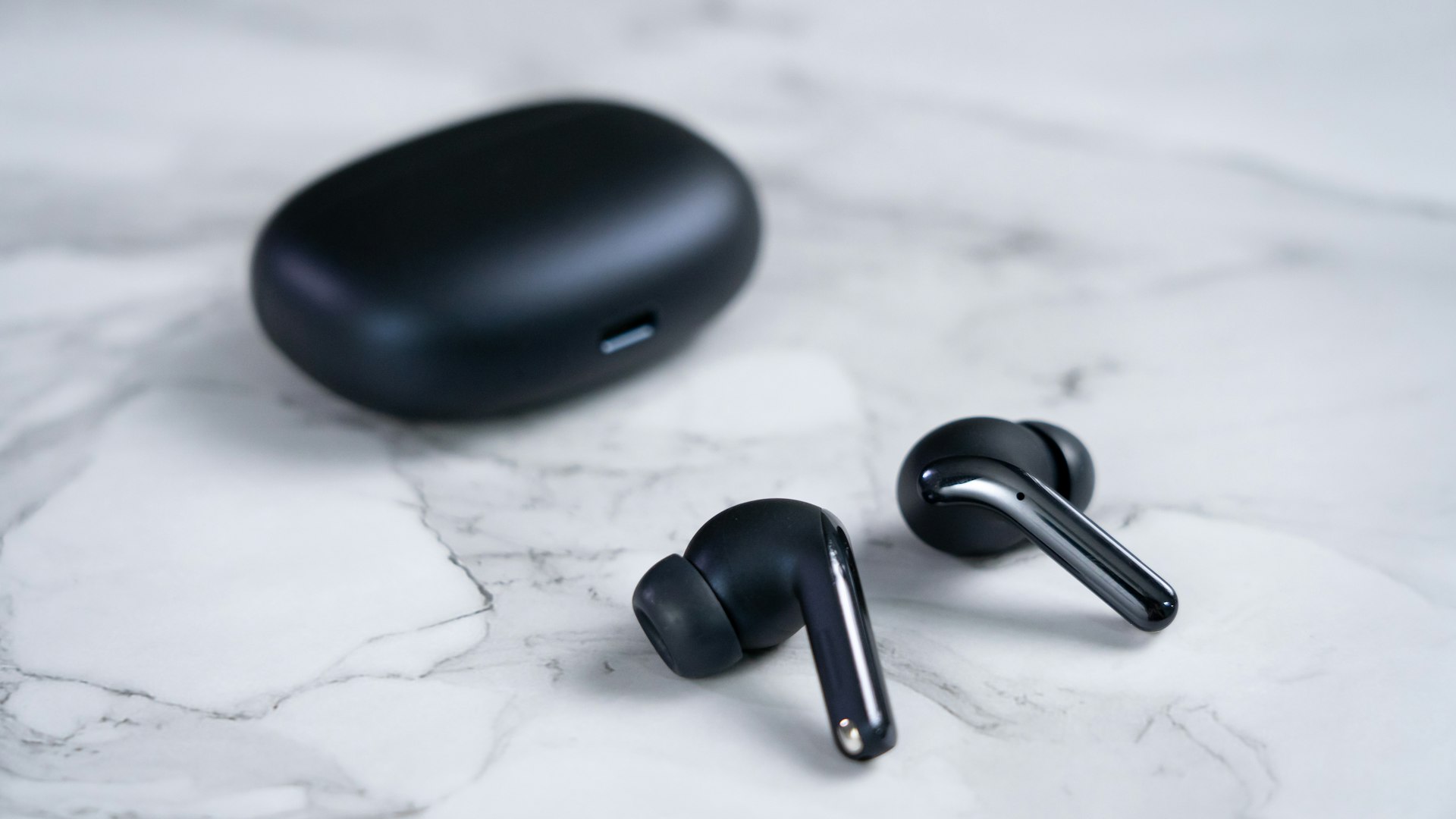 a black computer mouse and a black mouse on a white surface